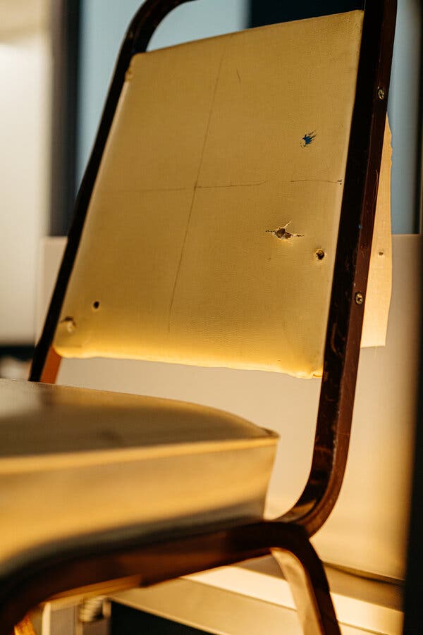 A chair from the Tree of Life Synagogue, riddled with bullet holes, also sits on display at the network’s headquarters. Credit: Jamie Kelter Davis for The New York Times